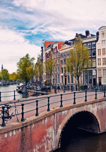 Beautiful view of Amsterdam canals with bridge and typical dutch houses. Holland
